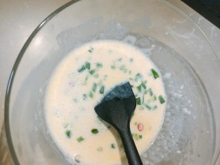 6、烤箱鸡蛋饼,小葱和米椒倒进蛋液混合均匀