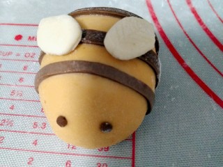 15、宝宝最爱的小蜜蜂豆包,沾点水粘在起豆包上，可爱的小蜜蜂就做好了，再发酵一小时，上锅蒸15分钟即可。