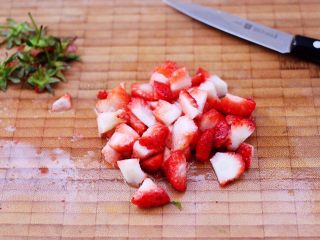 3、草莓芝士酥～蛋挞皮版,草莓洗净后，用刀把草莓切除尾部后，再切成小丁。