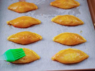 12、草莓芝士酥～蛋挞皮版,鸡蛋打散搅拌均匀后，把每个草莓芝士酥均匀刷上蛋液。