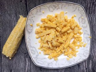 1、宝宝辅食之奶香玉米饼,新鲜甜玉米一根，先把玉米粒剥下来，或是像我一样直接用刀把玉米粒切下来，因为后面弄成玉米糊，所以并不要求必须完整的玉米粒