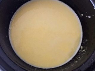 4、宝宝辅食之奶香玉米饼,玉米糊分成两部分，一半做粥，一半等会儿做玉米饼。取一半的米糊放进锅里，然后加水小火慢慢熬煮