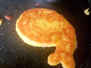 11、宝宝辅食之奶香玉米饼,等小火煎一会儿之后，面糊凝固，就可以轻轻去掉磨具了，翻过把另一面也煎制金黄，这个过程一定要小火哦，不然没有熟透就先糊掉喽