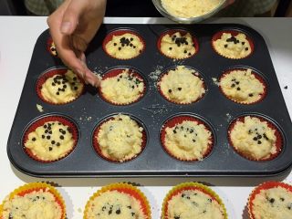 8、水果玛芬蛋糕,将耐高温巧克力豆适量洒在上面，并将制作好的金宝酥粒均匀撒在上面；放入烤箱中层，180度烤制25分钟左右即可，主要看蛋糕颜色呈金黄色便可取出。