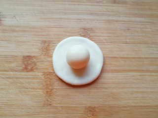 9、紫薯馅老婆饼,取一个油皮面团压扁，放上一份油酥面团。