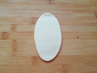 12、紫薯馅老婆饼,取一个包好的面团擀成牛舌状。