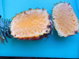 2、【宝宝营养餐】菠萝饭,菠萝从三分之一处切开，注意不要切到菠萝头部，要把菠萝花留下；