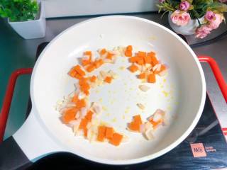 11、【宝宝营养餐】菠萝饭,另起锅，倒入核桃油，把胡萝卜和洋葱倒入翻炒2分钟；