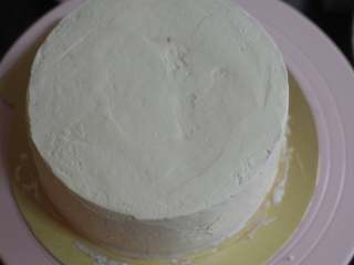 12、金秋蛋糕,外面用淡奶油抹面，两个蛋糕全部做好。然后借助刮刀，将4寸蛋糕小心地摆在6寸的蛋糕上，接缝处小心整理下，用多余的淡奶油修补。