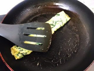 16、菠菜蛋卷,卷好后用铲子轻轻下压,使蛋卷更紧实;