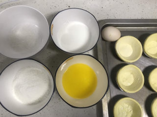 1、椰蓉蛋挞,称好材料备用，黄油隔热水融化，蛋挞皮提前解冻