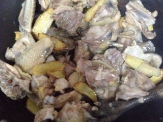 4、麻油姜爆子鸡,一边翻炒一边加入香菇.八角桂皮香叶.花椒粒辣椒.翻炒至鸡肉变色放入一些生抽.盐.鸡肉上色后倒入适量的水.大火烧开3分钟后转小火慢炖30分钟