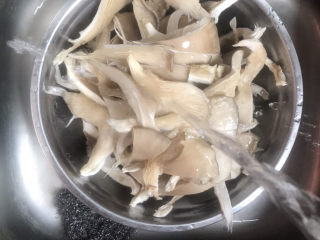 3、炸蘑菇,用水清洗干净,捏干水分