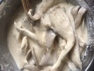 6、炸蘑菇,把蘑菇放入里面裹上面糊,面糊调稠点,蘑菇上多裹点面糊,炸出来才更脆(图片面糊有点稀了后来加面粉和了刚好忘记拍了)