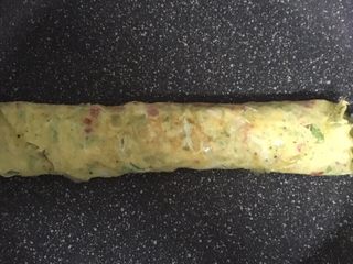 9、宝宝辅食之番茄芝士厚蛋烧,蛋液表面凝固后再次卷起，最后不断翻面煎至熟透。