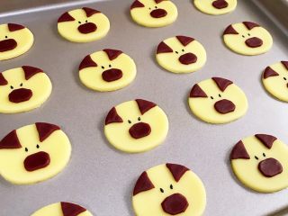 11、小猪曲奇,把小猪的耳朵和鼻子都贴上,用筷子粘上黑芝麻做眼睛,用尖一点的筷子或烧烤串的竹签扎出鼻孔。