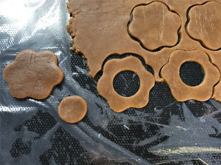 8、咖啡果酱小饼,再用一个小的圆形模具在面片中间抠出圆心。这个两个形状的面片数量要一致。