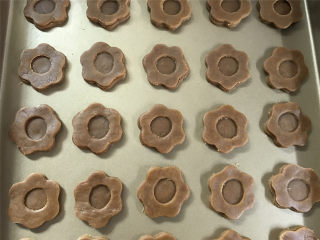 9、咖啡果酱小饼,然后把实心的花片放入烤盘中，再将另外那个有圆心的面片覆盖在上面。