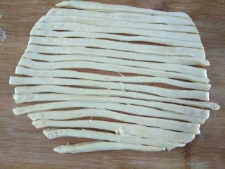 6、炸麻花,把面片用刀划成长条