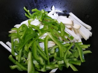 8、青椒炒杏鲍菇,放入杏鲍菇和青椒丝。