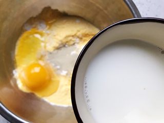 4、玫瑰花玉米面小蛋糕,缓缓加入牛奶，一边加一边用筷子搅拌