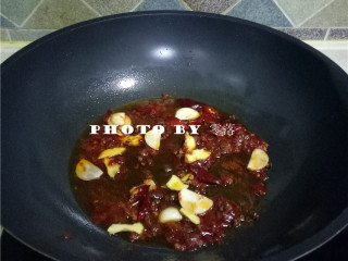 8、火爆肥肠,放入干辣椒、花椒、姜片,蒜片炒出香味;