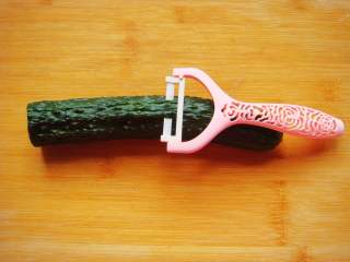 2、黄瓜花朵拼盘,用刨刀去掉顶处的一层外皮。