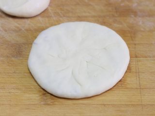 10、猪肉洋葱馅饼,用手把它轻轻摁圆摁平。