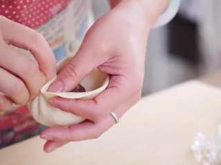 10、鲜肉包子,舀一勺肉馅放中间，捏起一个角形成褶，把面捏在褶上