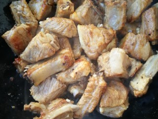 4、十味 红烧排骨,迅速翻炒均匀，让糖均匀的裹在排骨上，然后倒入两勺料酒。继续翻炒