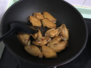 6、红烧翅中,立刻倒入煮好的翅中，翻炒均匀，使每个翅中都裹上糖浆。