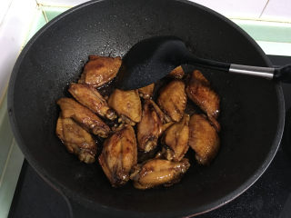 7、红烧翅中,然后加入酱油，料酒，炒均匀。