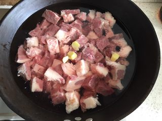 3、家常必备|土豆炖牛肉,冷水下锅,倒入适量料酒,加入姜片,开火,煮开后2分钟,关火