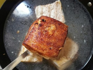 10、扣肉,盖锅盖用中火炸至锅里没噼里啪啦的声音，开盖观察至肉皮焦黄色捞出放入冷水中。