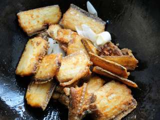 10、红烧带鱼最经典最家常的做法 可当热菜也可是冷盘 味道都一样好,放入炸好的鱼段翻炒几下。