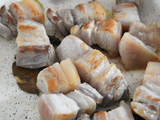 4、倒一瓶可乐进去，就能做一碗绝世红烧肉,炒香后，倒入五花肉，炒至五花肉出油，微微焦黄