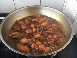 13、卤水鸡块,当炖20分钟后打开锅盖儿,把料包和香菜等调料挑出来扔掉,翻炒几下鸡块,使它上色均匀,这时注意要调一调味,翻炒后就是图片上的这种颜色,这时再用大火炖5分钟左右,卤汁也会更浓稠些,此时关火,盖上锅盖儿焖半个小时左右即可。