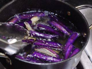 6、泰式酱烧茄子,用一个小的油炸锅,放多些的油,加热至六成热,下茄条炸至收缩定型变软。