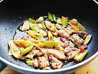 4、干锅千页豆腐,加入大葱和腌好的猪五花肉，中火炒制猪肉变色继续翻炒1分钟左右，加入蚝油、生抽炒匀。