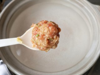 9、冬瓜丸子汤,锅中适量水(或者高汤),煮至微开(锅底刚开始冒小气泡),用勺子将肉糜挖圆入锅。