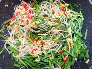 7、豆芽炒韭菜,再倒入韭菜,翻炒至韭菜熟为止。