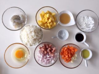1、虾仁菠萝炒饭,准备好所有食材,菠萝洗净用盐水浸泡十分钟后取出切丁,火腿、洋葱、胡萝卜切丁,蒜切末