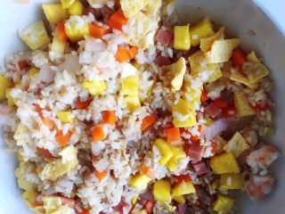 8、虾仁菠萝炒饭,加入鸡蛋薄饼、切块虾仁和菠萝丁翻炒均匀出锅即可