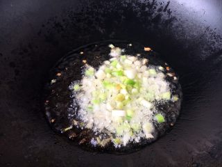 7、孩子爱吃的西红柿鸡蛋打卤面,开大火置锅，放适量油，随后马上放入洋葱粒、蒜粒，炒出香味再放葱花。