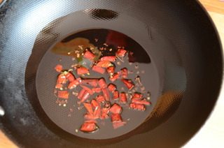 15、酸菜鱼,重新取干净炒锅，热锅凉油放入花椒和干红辣椒，小火炸至辣椒棕红油亮