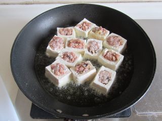 7、客家酿豆腐,热锅放入适量的油， 下入酿好的豆腐块里面去煎；