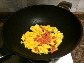 8、秋葵炒蛋,放入火腿肠翻炒10秒。