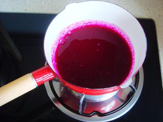 2、莲蓉花朵和果子,把果汁倒入小锅里。