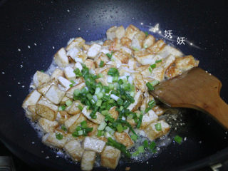 8、孜然小葱煎豆腐,加入小葱和盐。