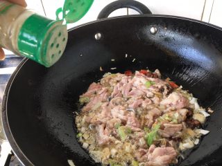 10、老天津卫三鲜打卤面,当肉片稍稍变色定形型时放入1小勺白胡椒粉并翻炒，让肉均匀受热，再沿锅边倒入2勺料酒，翻炒几下。